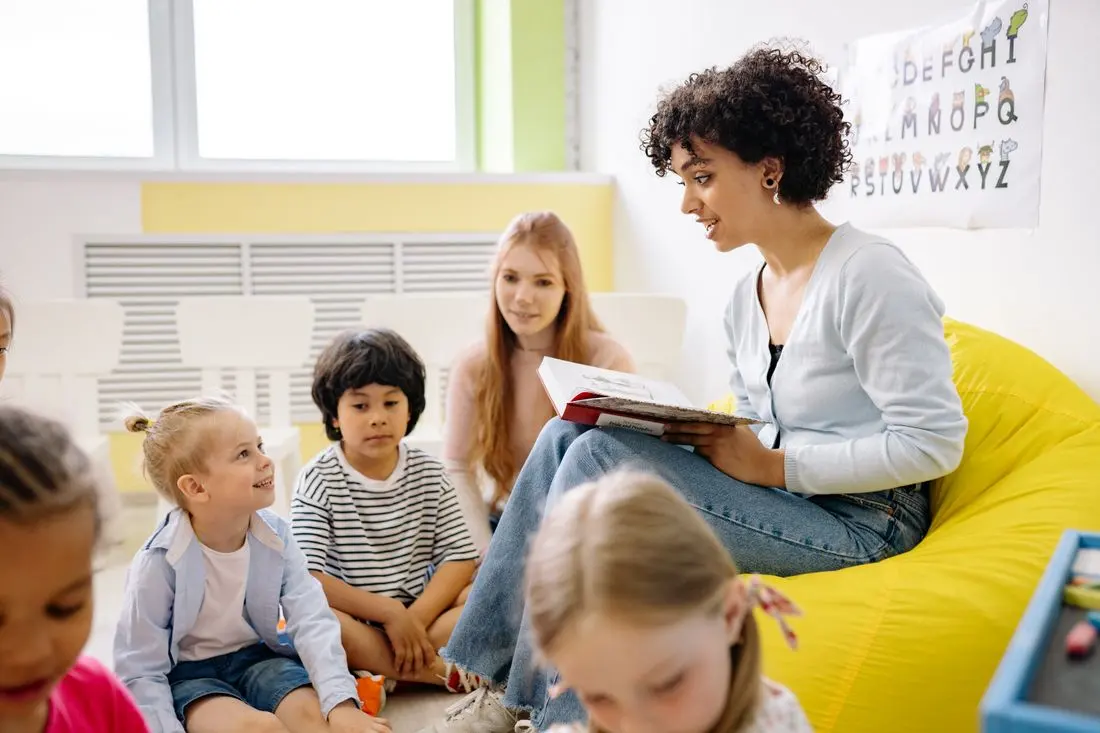 A teacher reading a picture book to young children